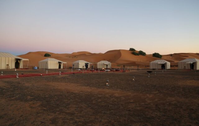 Traditional desert camp surrounded by Erg Chebbi sand dunes